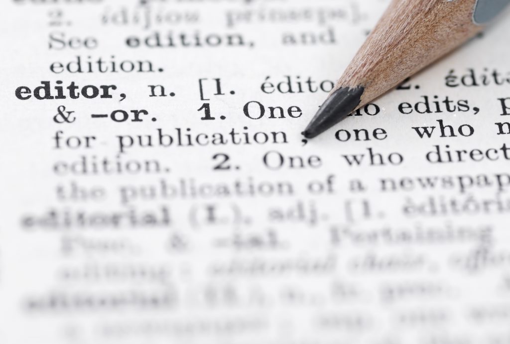 The definition of editor in a English dictionary Shallow DOF, focus on editor and nib of pencil.
